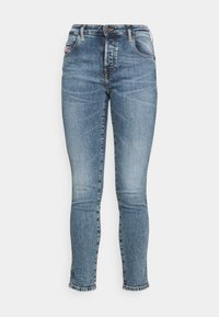 Jeans de mezclilla azul oscuro con corte slim, que presentan un desgaste descolorido, diseño de cinco bolsillos y un cierre de cremallera con botón. Terminados en los tobillos.