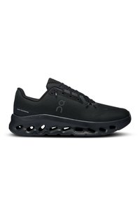 Chaussures de sport noires avec un dessus texturé, un système de laçage et une semelle rembourrée avec des découpes visibles pour la flexibilité et le soutien.