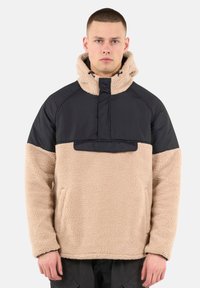 Beiger Fleece-Pullover mit einem schwarzen Nylon-Oberteil und Kapuze, ausgestattet mit einem Viertelreißverschluss, Taschen auf der Vorderseite und einer weichen, strukturierten Oberfläche.