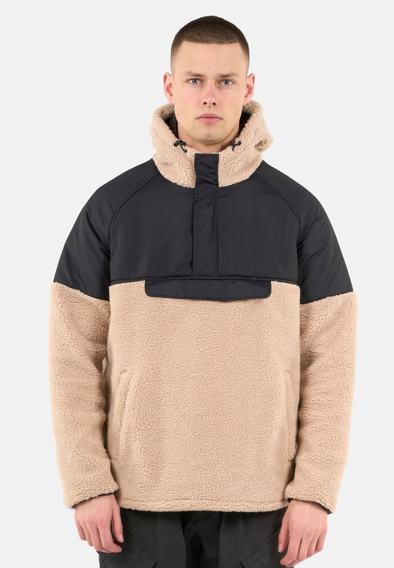 Beiger Fleece-Pullover mit einem schwarzen Nylon-Oberteil und Kapuze, ausgestattet mit einem Viertelreißverschluss, Taschen auf der Vorderseite und einer weichen, strukturierten Oberfläche.