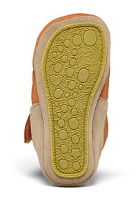 Zapato de cuero marrón con una suela texturada de color beige. La suela presenta patrones en relieve que incluyen círculos y estrellas en un color amarillo-verde.