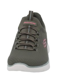 Graue Netz-Sportschuh mit rosa Akzenten, der eine strukturierte Oberfläche, eine abgerundete Zehenpartie und eine weiße Sohle aufweist. Die Schnürsenkel sind in das Oberdesign integriert.