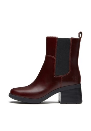 Mørkebrun læderankelstøvle med sort elastisk sidepanel, blokhæl og trækstrop bagpå.