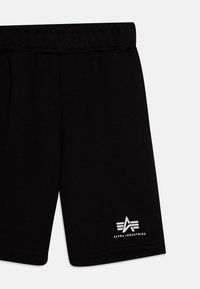 Black cotton shorts with an elastic waistband, featuring a white logo with three stripes at the bottom left corner. Smooth texture.