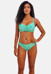Groene en witte gestreepte bikini set met een gerimpelde top met verstelbare bandjes en bijpassende lage broek. Glad materiaal en aangesloten ontwerp.
