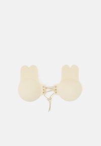 Soutien-gorge beige, doux, avec des bonnets arrondis et des formes d'oreilles de lapin. Présente un détail lacé au centre. Texturé lisse, design minimaliste.