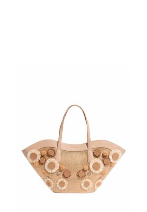 Slamená taška s širokým horným okrajom, béžovými koženými rúčkami a 3D kvetinovými aplikáciami v bielej a hnedej farbe na prednej a bočných stranách.