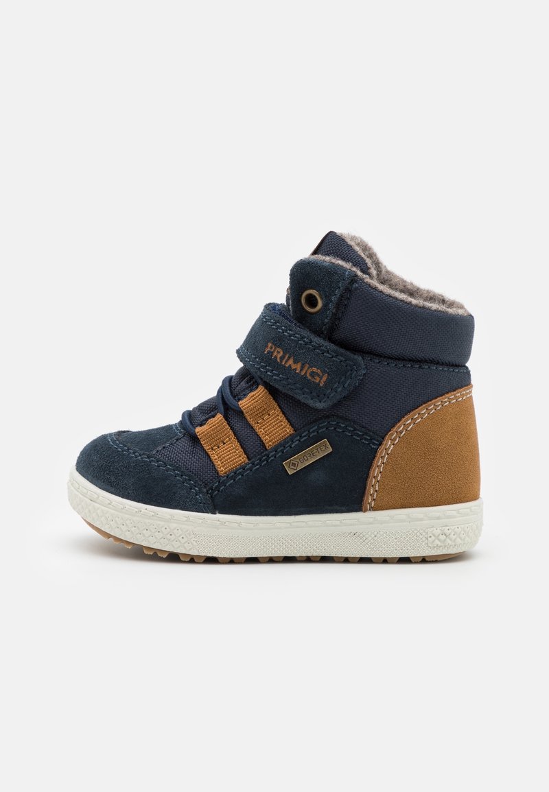Baskets montantes bleu marine pour tout-petit avec accents marron, semelle blanche, fermeture à scratch, lacets et doublure en polaire, marquées Primigi et Gore-Tex.