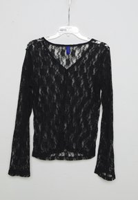 Blouse noire en dentelle à manches longues avec un décolleté en V, ornée de motifs floraux raffinés et de manches légèrement évasées, accentuée par du matériel épaule.