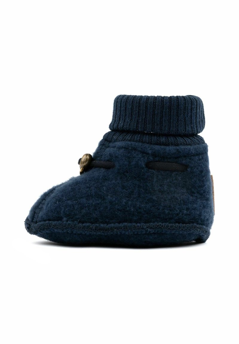 Chausson bébé en polaire bleu marine avec bord-côte à la cheville et fermeture par bouton-pression latéral, présenté de profil sur fond blanc.