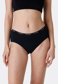 Slip in cotone nero con elastico che presenta la parola "LOVABLE" in lettere rosse. Texture liscia, design classico, forma alta.