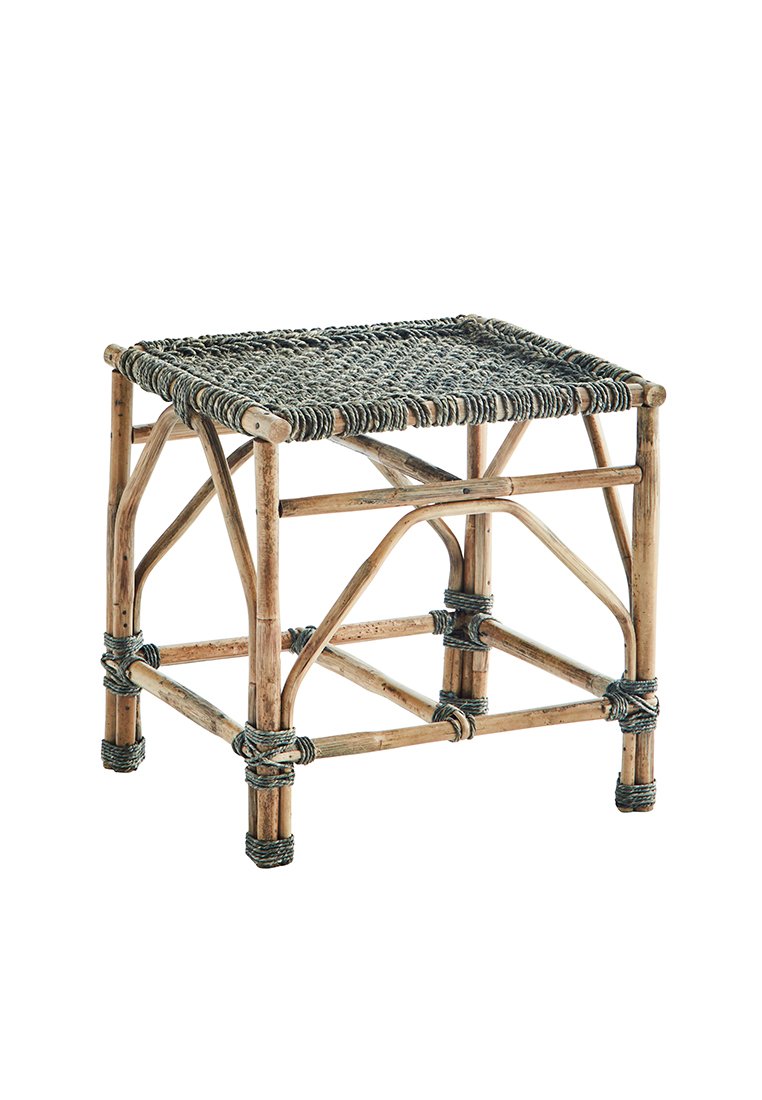 Rieten kruk met een rechthoekig geweven zitvlak in zwart en grijstinten, ondersteund door natuurlijke bamboepoten, met decoratieve knoopaccenten.