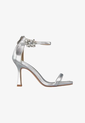 Sandal alta con tacco, argentata e con finitura metallica, con cinturino sottile alla caviglia e decorazioni in gemme sul fermaglio. Design open-toe.