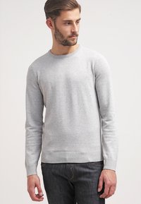 Grå långärmad tröja med rund hals, tillverkad av stickad tyg. Har ribbade ärmslut och fåll, enkel design utan mönster.