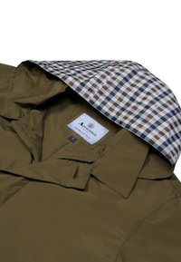 Olivengrüne Jacke mit einem karierter Innenkapuze Futter in Marineblau, Burgunderrot und Weiß. Verfügt über ein Etikett innen und einen Reißverschluss auf der Vorderseite.