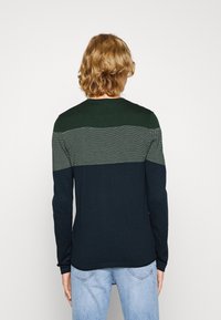 Pull à manches longues en vert foncé et bleu marine avec un motif de tricot texturé et des rayures horizontales contrastantes dans le dos.