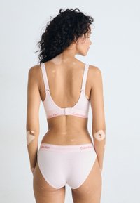 Lichtroze Calvin Klein beha en slipset met verstelbare banden, logo-accenten en een zachte, rekbare stof. Minimalistisch ontwerp met een comfortabele pasvorm.