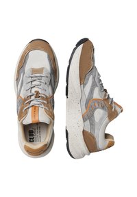 Baskets avec un mélange de daim gris et d'accents en cuir brun, présentant une semelle intercalaire texturée crème et une semelle extérieure en caoutchouc noir. Design minimaliste.