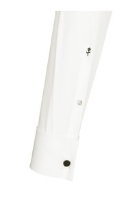 Poignet d'une chemise blanche avec une broderie de fleur noire, un bouton transparent et un accent de bouton noir au poignet. Tissu lisse avec un design net.