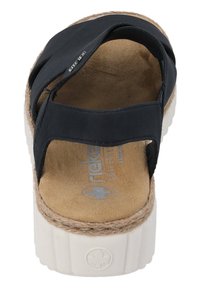 Czarne sandały z krzyżowym paskiem, z miękką zamszową wkładką, białą platformą i wykończeniem ze sznurka juty wokół krawędzi podeszwy.