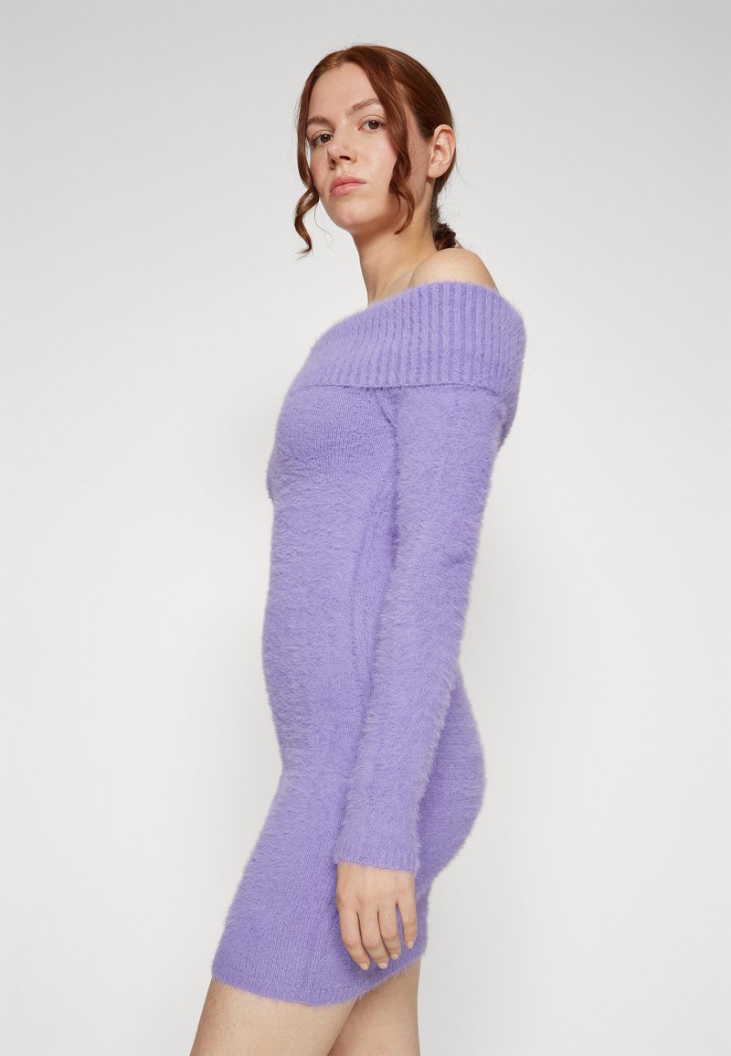 Violette Strickkleid mit schulterfreiem Design, flauschiger Textur, figurbetontem Schnitt und langen Ärmeln, das bis zur Mitte des Oberschenkels reicht.