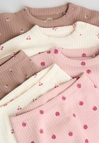Trois ensembles de vêtements bébé côtelés en rose, crème et marron, chacun avec des motifs cerises ou floraux et des boutons-pression sur l'épaule.