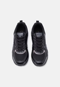 Ζευγάρι μαύρα αθλητικά παπούτσια με πλέγμα επάνω μέρος, κλείσιμο με κορδόνια και θηλιές έλξης, σε θέα από πάνω σε λευκό φόντο.
