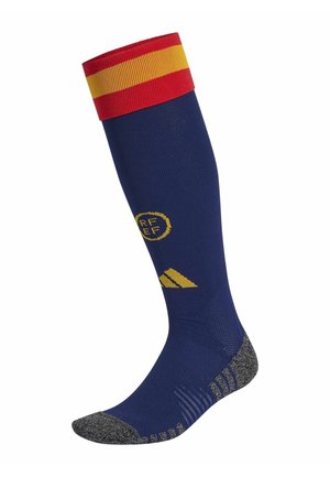 Navy soccer sock with red and yellow striped cuff, textured gray footbed, yellow branding, and ribbed design for enhanced grip.
