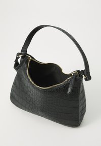 Borsa nera con motivo coccodrillo, dalla forma strutturata, con chiusura superiore a zip e manico corto; l'interno presenta una fodera a contrasto.