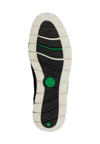 Schwarze Gummisohle mit strukturiertem Grip-Muster, weißer Mittelsohle und grünem Akzent nahe der Ferse. Rundes Logo in der Mitte.