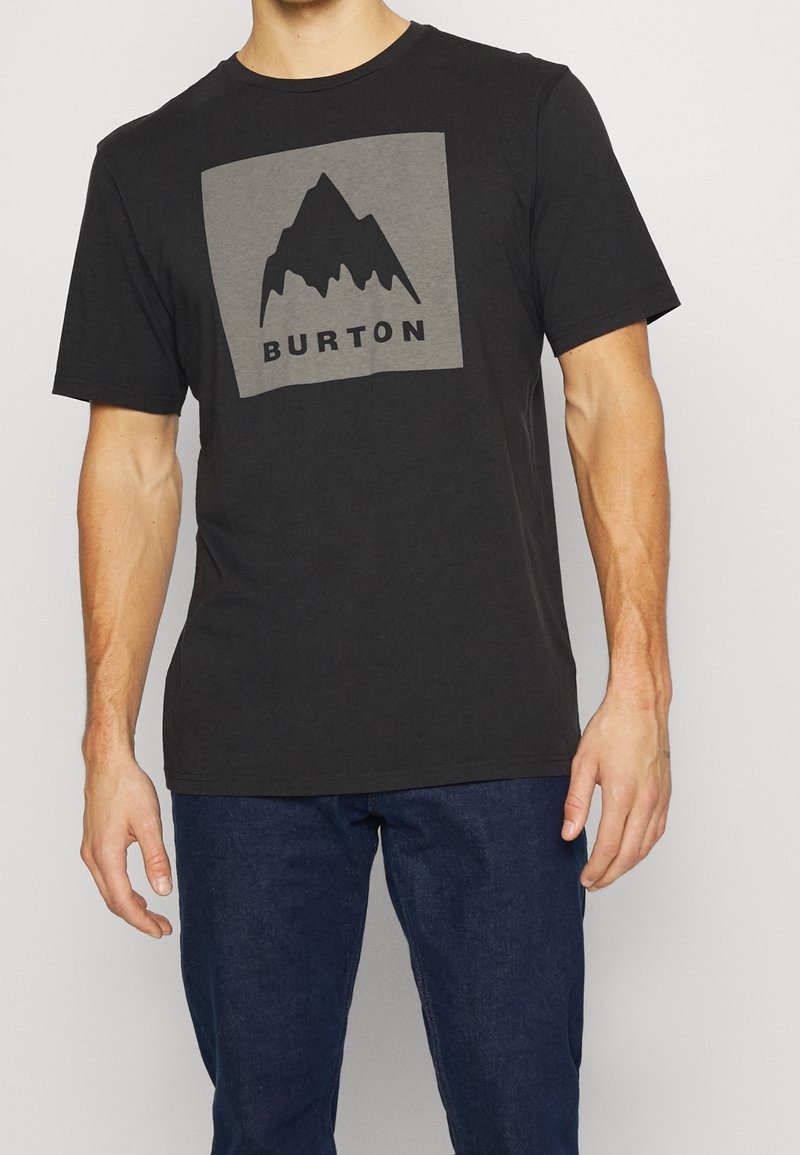 Černé bavlněné tričko s krátkým rukávem, které má šedý čtvercový logo s designem hory a slovem "BURTON". Kolo výstřih a standardní střih.