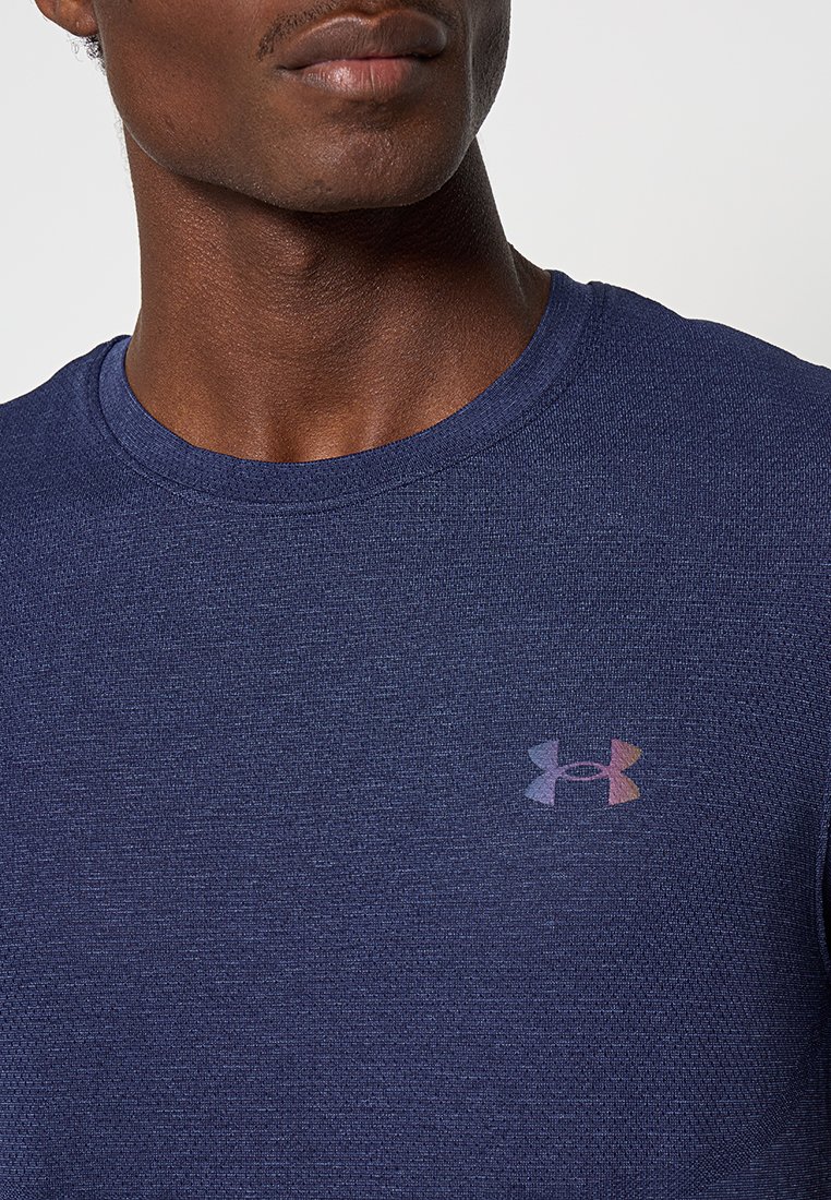 Marineblaue Sport-T-Shirt aus strukturiertem Stoff, mit einem kleinen, mehrfarbigen Under Armour-Logo auf der Brust. Runder Ausschnitt.