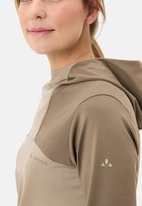 Maglione con cappuccio beige con una finitura testurizzata, caratterizzato da un design a pannelli in contrasto e un sottile dettaglio del logo sul petto e sulla manica.