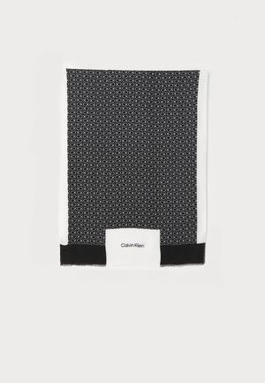 Czarno-biały szalik z powtarzającym się wzorem logo CK i napisem Calvin Klein na białym panelu tła w pobliżu końca.