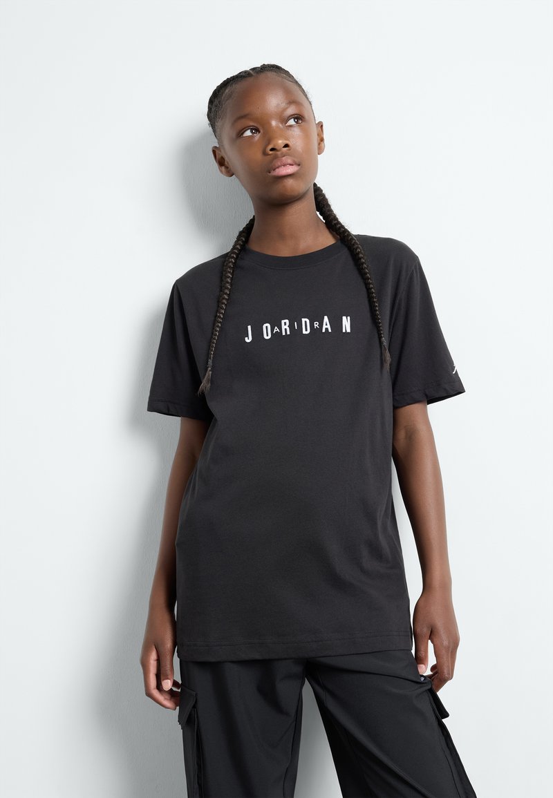 Svart bomulls t-shirt med "JORDAN" tryckt på bröstet i kontrasterande vita bokstäver, med en avslappnad passform och korta ärmar.