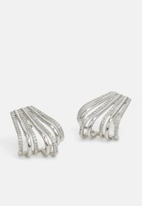 Pendientes en tono plateado con diseños de ondas curvadas y acentos brillantes, hechos de metal, que destacan por su textura suave y brillante.