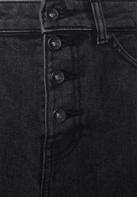 Jeans de ganga pretos com um design de cintura alta, com fecho de cinco botões, costuras visíveis e um bolso frontal.