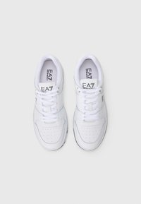 Par bijelih EA7 Emporio Armani tenisica s vezicama, ventilacijskim otvorima i brendiranim jezikom i bočnim logotipima, prikazane iz gornjeg pregleda.