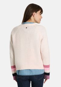 Helles pinkes Sweatshirt mit langen Ärmeln, das mehrfarbige gestreifte Akzente in Pink, Schwarz und Lila aufweist; weiche Textur; rundes Rückenkleid.