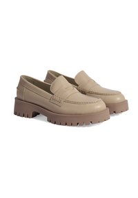 Mocassins en cuir beige avec une épaisse semelle en caoutchouc brune texturée, présentant un design cousu sur le dessus et une forme de chaussure arrondie.