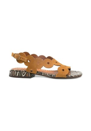 Sandalo piatto con cinturini smerlati in camoscio color cuoio con fori circolari e fibbia alla caviglia, su suola con motivo effetto pelle di serpente testurizzata.