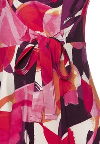 Blumenmusterstoff in lebhaften Rosa-, Rot- und Lilatönen. Mit einer gebundenen Taillenpartie und glatter Textur, sowie einem strukturierten Design.