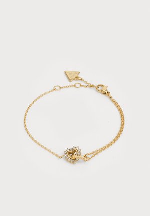 Gold chain bracelet featuring a heart-shaped clasp adorned with rhinestones. The chain is delicate and consists of interlinked links.