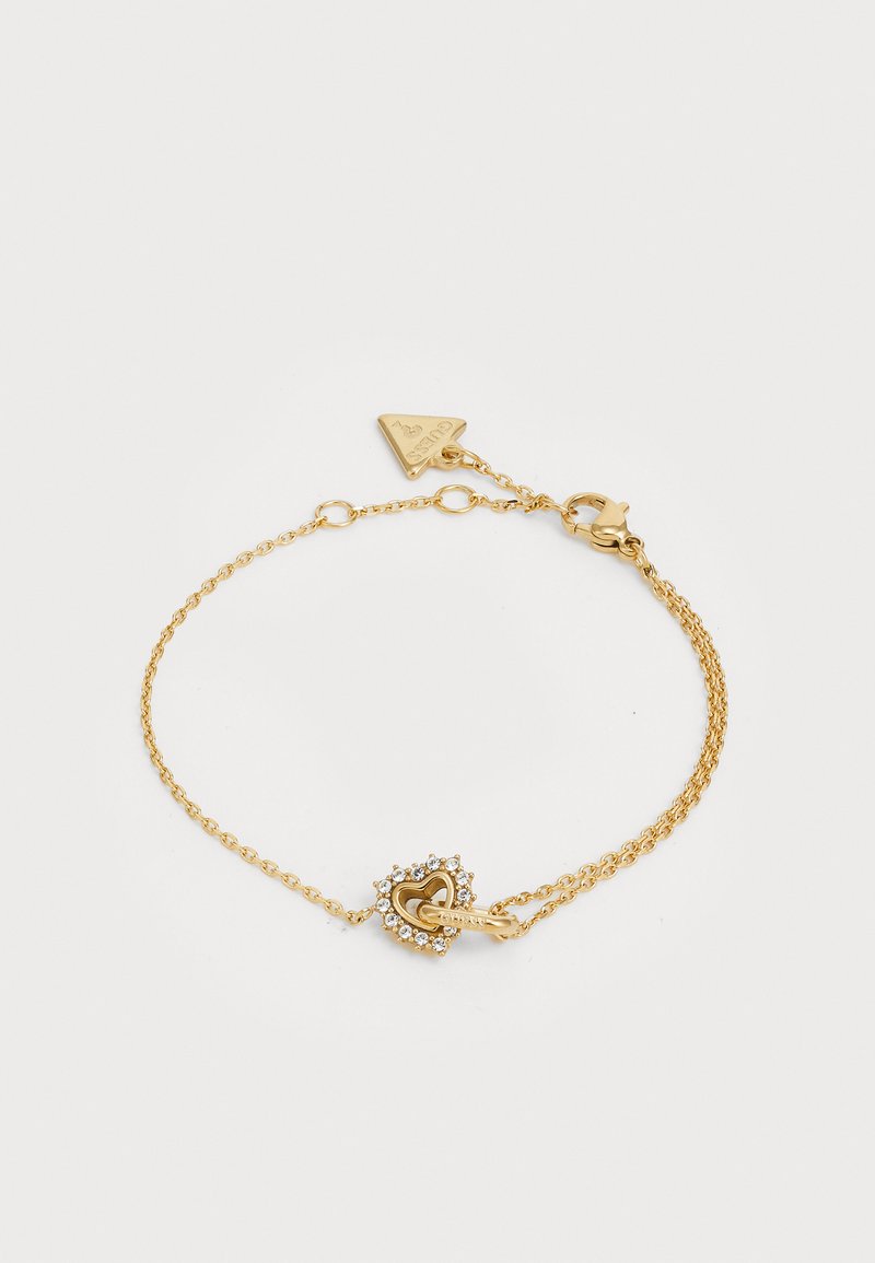 Gullringbundet armbånd med en hjertformet lås dekorert med rhinestones. Kjeden er delikat og består av sammenkoblede ledd.