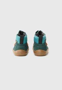 Scarpe per bambini mid-top in suede teal e verde, con tomaia testurizzata, linguetta e dettagli arancioni sul tallone. Suola in gomma.