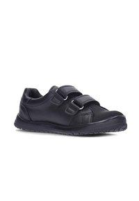 Zapatilla deportiva negra con doble tira de velcro, parte superior de cuero liso y tejido texturizado, suela de goma con patrón de agarre y diseño de perfil bajo.