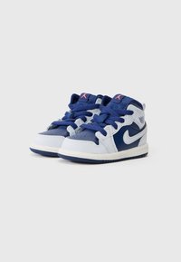 Par tenisica veličine za malu djecu, tamnoplave i bijele Nike Air Jordan s ružičastim Jumpman logotipima i plavim vezicama na bijeloj pozadini.