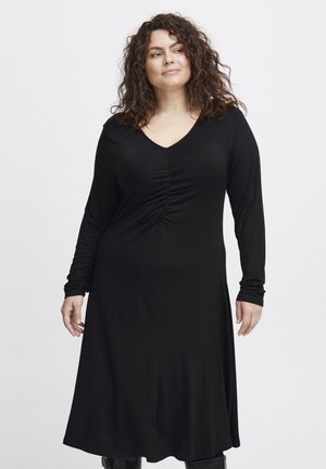 Svart långärmad klänning i mjukt tyg, med V-ringning och draperade detaljer framtill, samt en svängig kjol.