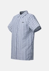 Chemise à manches courtes boutonnée avec des rayures verticales bleues et blanches et une poche poitrine étiquetée "Seaside."