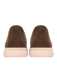 Paar braune Wildleder-Sneaker mit dicken weißen Gummisohlen, von hinten auf weißem Hintergrund gesehen.